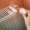 Hand,Adjusting,The,Knob,Of,Heating,Radiator